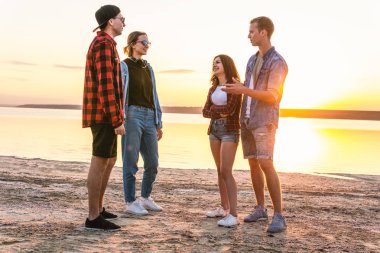 birlikte yürüyüş sırasında sunset beach üzerinde çift arkadaşlar