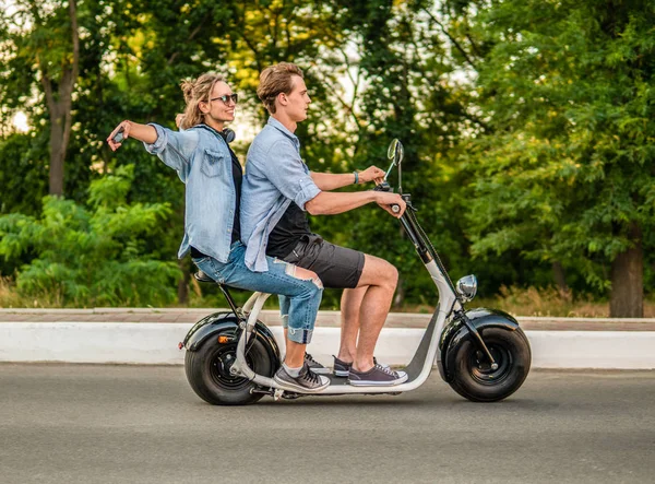 여름 동안 전기 자전거를 운전 하는 사랑 스러운 젊은 부부 — 스톡 사진