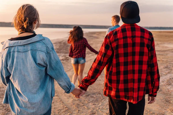 Amigos en la playa juntos caminando al atardecer — Foto de Stock