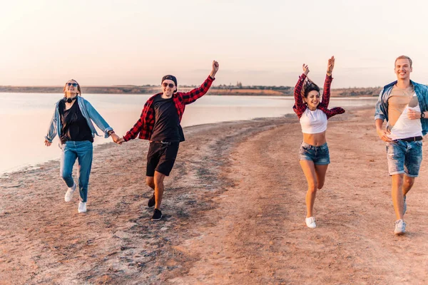 Jóvenes amigos hipster en la playa corriendo juntos — Foto de Stock