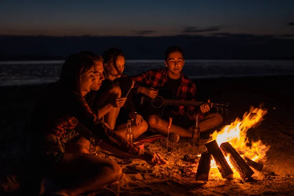 Junge Freunde picknicken mit Lagerfeuer am Strand — Stockfoto