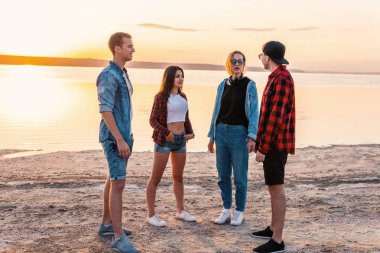 birlikte yürüyüş sırasında sunset beach üzerinde çift arkadaşlar