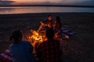 Sahilde piknik şenlik ateşi ile genç arkadaşlar