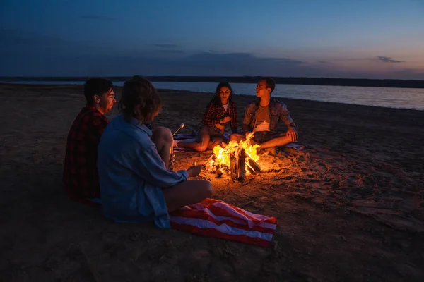 Junge Freunde picknicken mit Lagerfeuer am Strand — Stockfoto