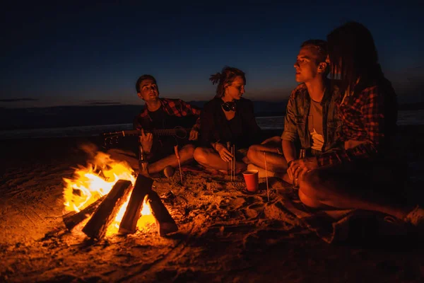 Junge Freunde picknicken mit Lagerfeuer am Strand — Stockfoto