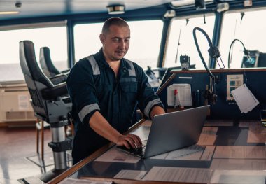 Deniz seyir subayı laptop ya da defter denizde kullanıyor