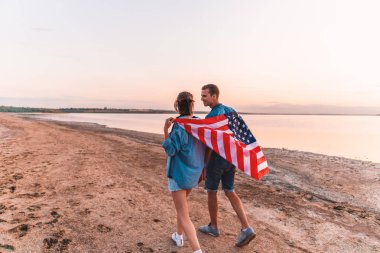 Amerikan çift Amerikan bayrağı sahilde yürüyüş kaplı