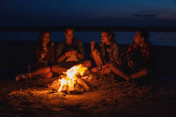 Junge Freunde picknicken mit Lagerfeuer am Strand — Stockfoto