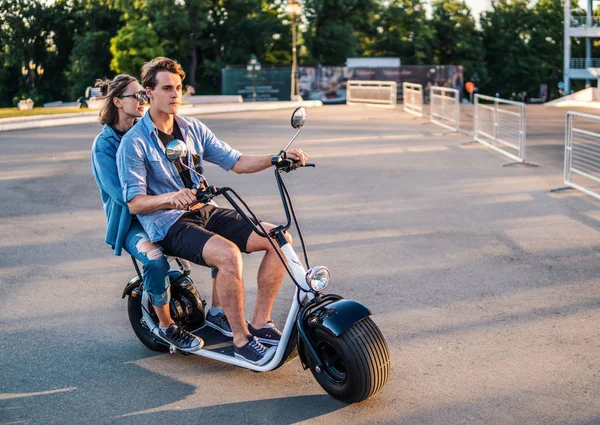 Adorável jovem casal feliz dirigindo bicicleta elétrica — Fotografia de Stock