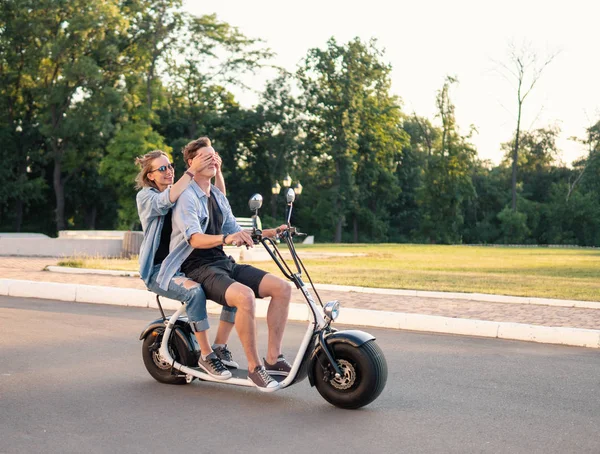 Preciosa joven feliz pareja conduciendo bicicleta eléctrica —  Fotos de Stock