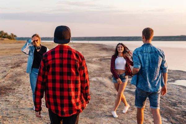 Amigos en la playa juntos caminando al atardecer — Foto de Stock