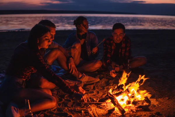 Junge Freunde picknicken mit Lagerfeuer am Strand — Stockfoto