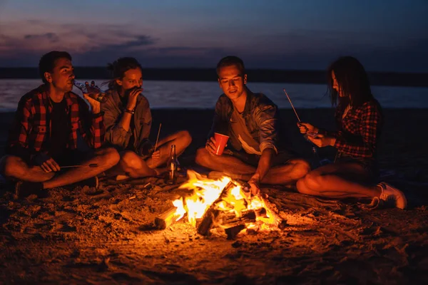 Junge Freunde picknicken mit Lagerfeuer am Strand — Stockfoto