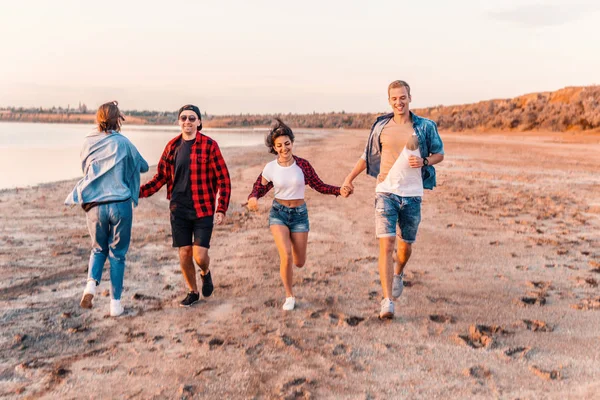 Jóvenes amigos hipster en la playa corriendo juntos — Foto de Stock
