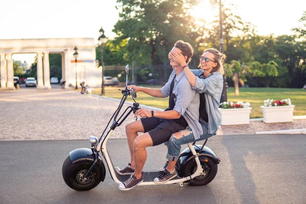 Preciosa joven feliz pareja conduciendo bicicleta eléctrica —  Fotos de Stock