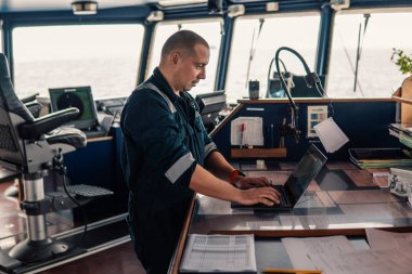 Deniz seyir subayı laptop ya da defter denizde kullanıyor