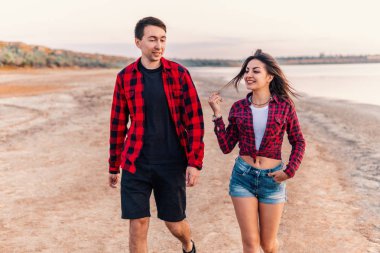 oung çift sahilde birlikte yürüme