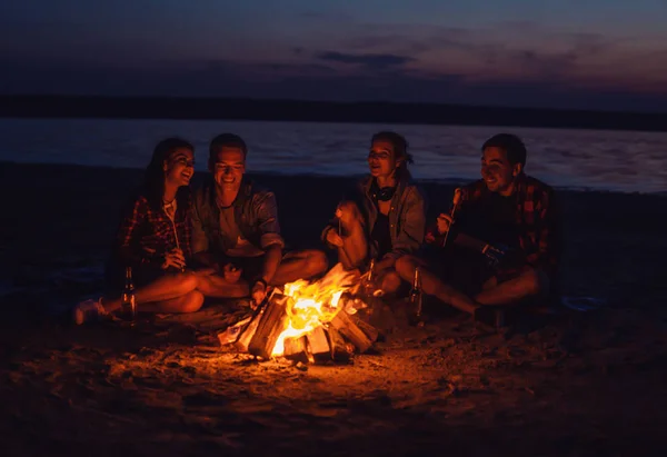 Junge Freunde picknicken mit Lagerfeuer am Strand — Stockfoto