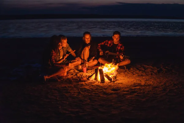 Giovani amici hanno pic-nic con falò sulla spiaggia — Foto Stock