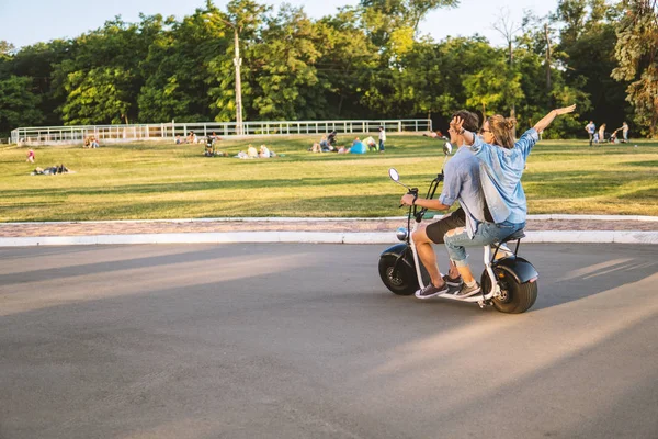 Preciosa joven feliz pareja conduciendo bicicleta eléctrica —  Fotos de Stock