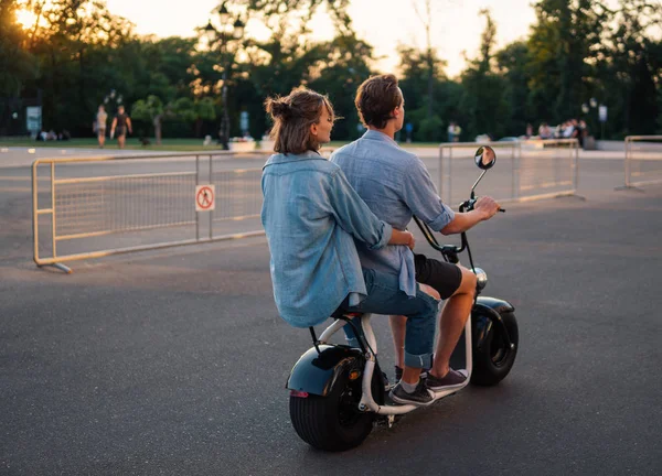 Charmant jeune couple conduisant un vélo électrique pendant l'été — Photo