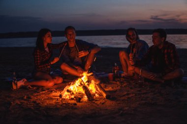 Sahilde piknik şenlik ateşi ile genç arkadaşlar
