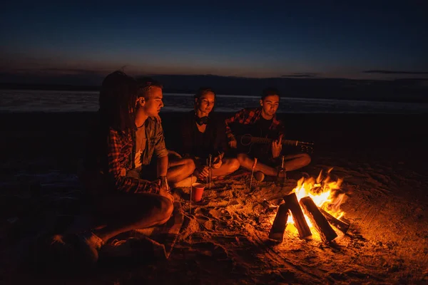 Junge Freunde picknicken mit Lagerfeuer am Strand — Stockfoto