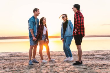 birlikte yürüyüş sırasında sunset beach üzerinde çift arkadaşlar