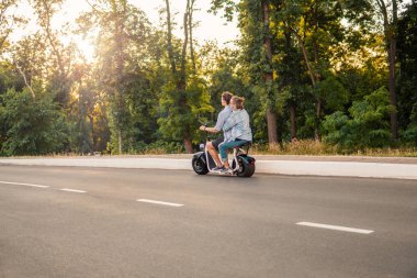 Güzel genç çift sürüş sırasında yaz Modern şehir hayatı elektrikli bisiklet ve ulaşım