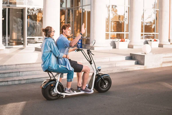 Preciosa joven feliz pareja conduciendo bicicleta eléctrica —  Fotos de Stock