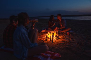 Sahilde piknik şenlik ateşi ile genç arkadaşlar