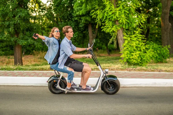 Urocza młoda para jazdy rower elektryczny latem — Zdjęcie stockowe