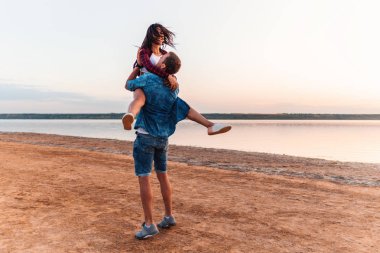 oung çift sahilde birlikte yürüme