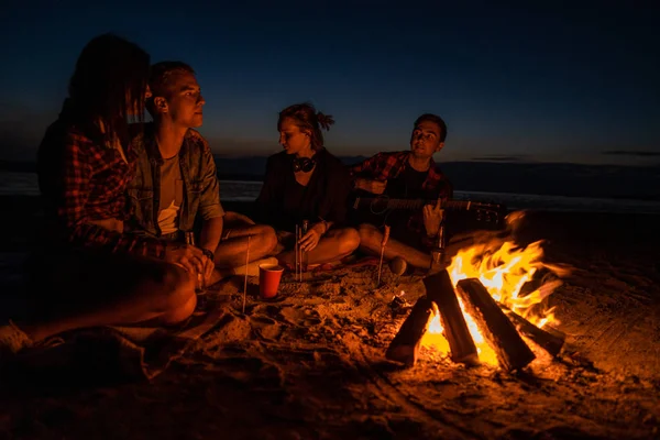 Jovens amigos fazem piquenique com fogueira na praia — Fotografia de Stock