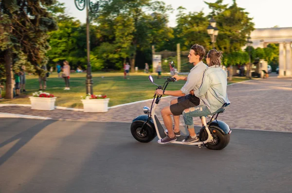 Mooie jonge gelukkige paar rijden elektrische fiets — Stockfoto