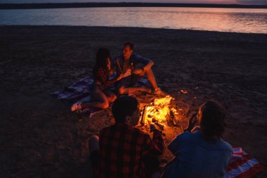 Sahilde piknik şenlik ateşi ile genç arkadaşlar