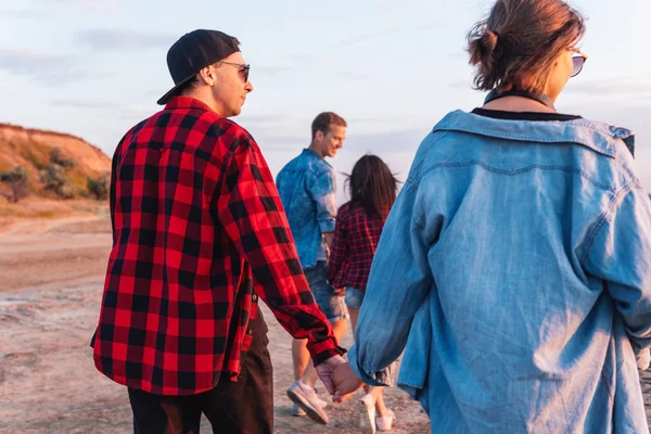 Amigos en la playa juntos caminando al atardecer — Foto de Stock