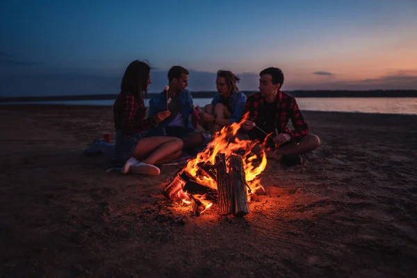 Junge Freunde picknicken mit Lagerfeuer am Strand — Stockfoto