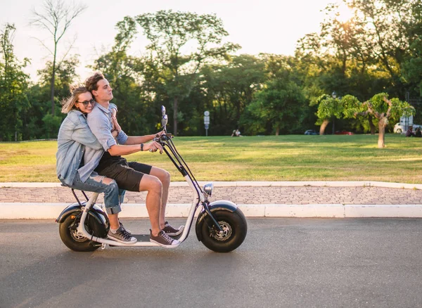 Preciosa joven feliz pareja conduciendo bicicleta eléctrica — Foto de Stock