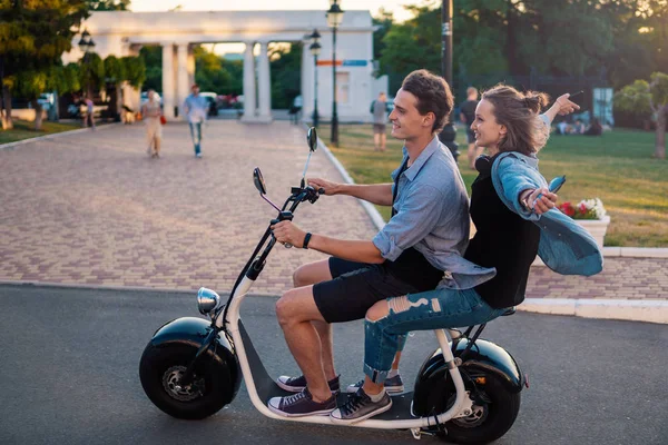 Charmant jeune couple conduisant un vélo électrique pendant l'été — Photo