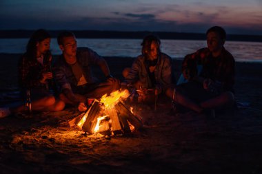 Sahilde piknik şenlik ateşi ile genç arkadaşlar