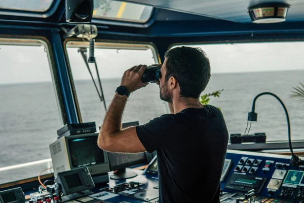 Navigointiupseeri katselee navigointivahtia kiikarien läpi — kuvapankkivalokuva