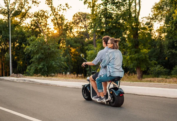 Preciosa pareja joven conduciendo bicicleta eléctrica durante el verano —  Fotos de Stock
