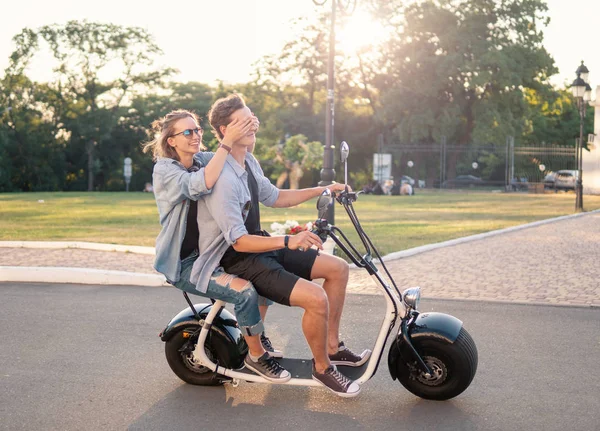 Lovely young happy couple driving electric bike — Stock Photo, Image