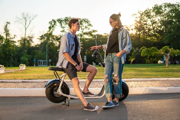 Adorável jovem casal feliz com bicicleta elétrica — Fotografia de Stock