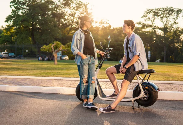 Preciosa joven feliz pareja con bicicleta eléctrica —  Fotos de Stock