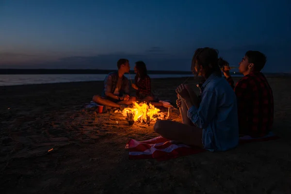 Junge Freunde picknicken mit Lagerfeuer am Strand — Stockfoto