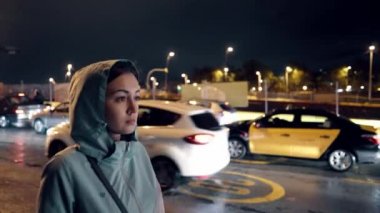 Yorgun kız işten sonra karanlık bir sokakta yürümek. Gece şehir hayatı bokeh ışıkları ile