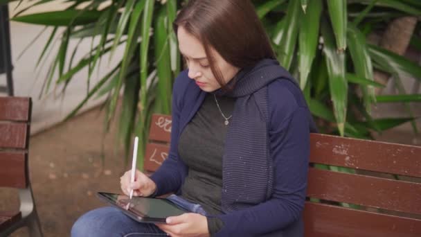 Zeitlupenaufnahme einer Frau, die mit Stift auf einem digitalen Tablet zeichnet — Stockvideo