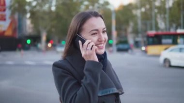 şehir meydanında telefonda konuşurken şık iş kadını